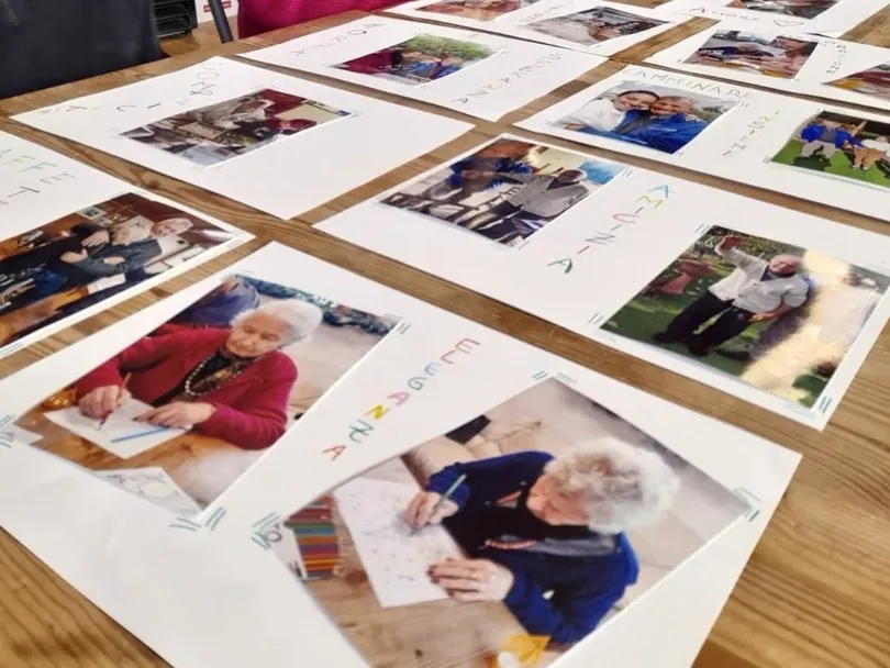 Fotografie stampate e cartoncini con i nomi disposti su un tavolo per un esercizio di memoria