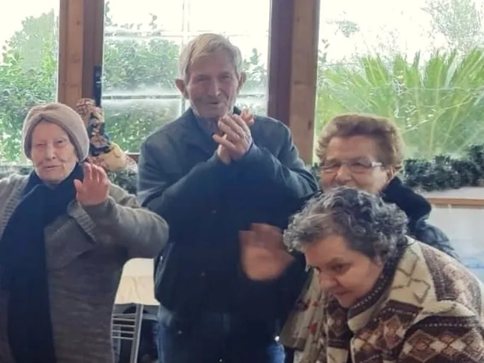 Alcuni anziani applaudono durante la festa di Natale